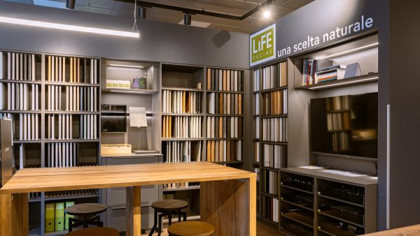 Studio moderno con cucina Life: tavolo legno, librerie, TV e scrivania organizzata