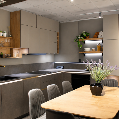 Cucina moderna Life con mobili grigio scuro, ripiani illuminati, tavolo legno e sedie grigie.