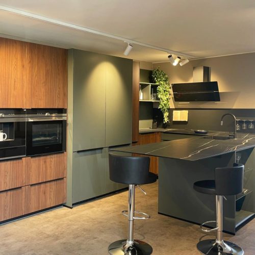 Cucina moderna Life con isola nera, frontali legno, elettrodomestici integrati e sgabelli design.