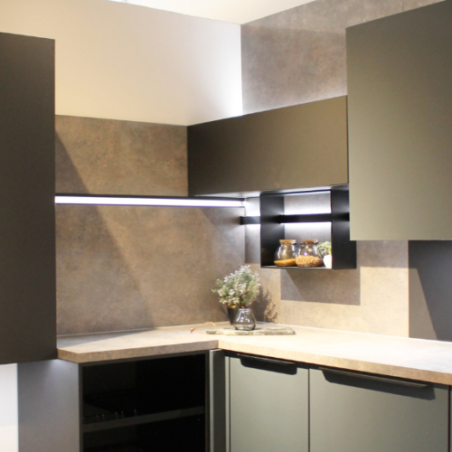 Cucina moderna angolare con ante grigie, piano in pietra e alzata rivestita, illuminazione led integrata